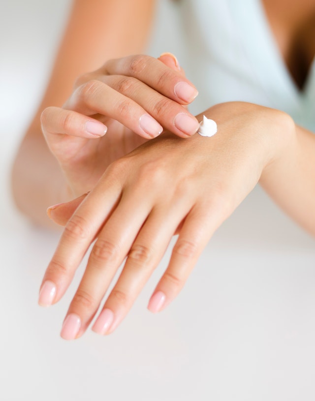Female Hands Applying Cream