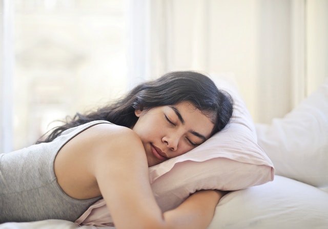 female sleeping facing down with pillow